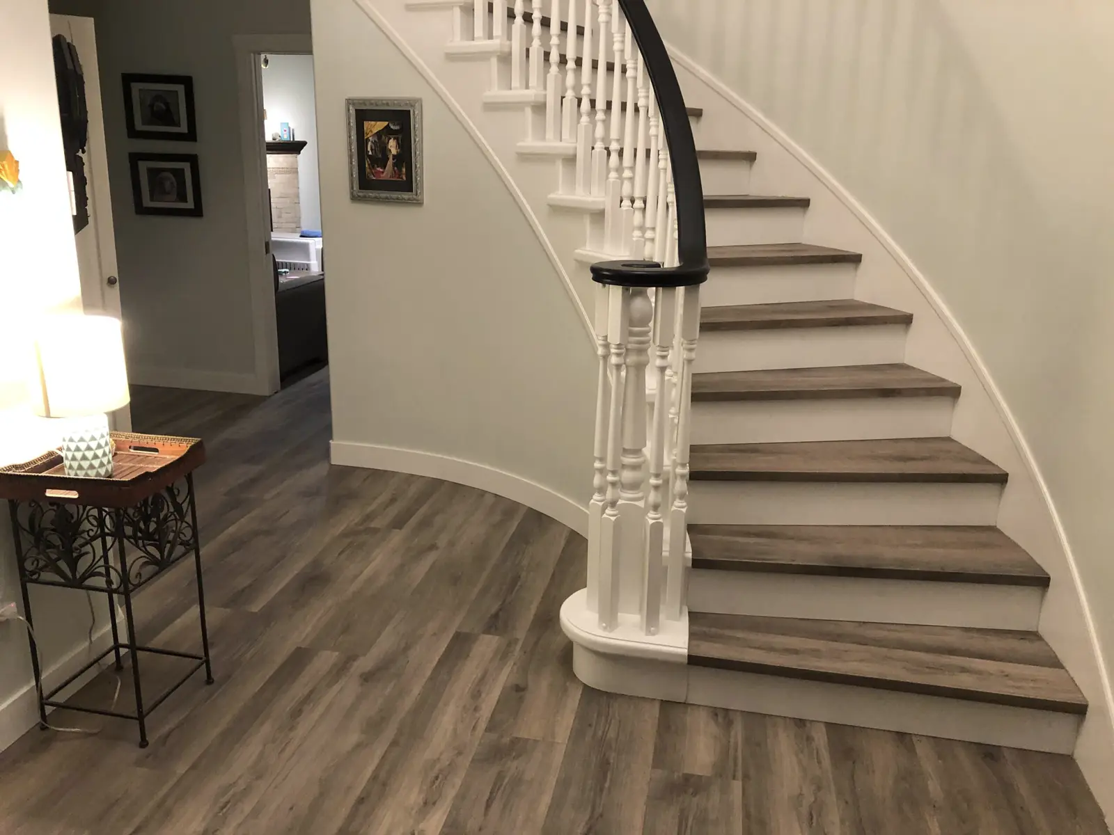 A curved staircase and hallway finished in wide grey oak plank
